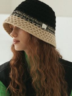 a woman with long hair wearing a black and white hat while looking off to the side