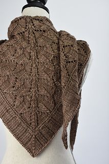 a knitted shawl on top of a mannequin's head wearing a brown sweater