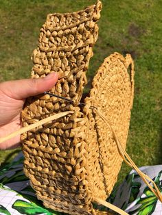 a person is holding two woven baskets in their hands and knitting them on the grass