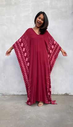 Indulge in the beauty of our classic kaftan with hand silk-screen printed fabric. This kaftan dress boasts unique patterns on high-quality rayon fabric. Its versatile design allows you to create many stylish looks, ensuring you always feel your best, whether you're at home or stepping out. Red Bohemian Kaftan With Ikat Print, Red Flowy V-neck Kaftan, Red Bohemian Flowy Kaftan, Flowy Red Bohemian Kaftan, Red V-neck Free Size Kaftan, Red Batik Print Maxi Dress, Flowy Red Printed Kaftan, Red Flowy Kaftan With Kimono Sleeves, Red Bohemian V-neck Kaftan