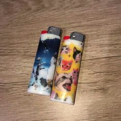 two lighters sitting on top of a wooden table