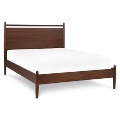 a wooden bed frame with white sheets on it