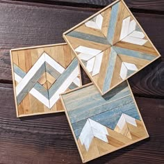 three wooden coasters with arrows painted on them sitting on top of a wood table