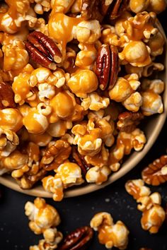 a bowl filled with caramel popcorn and nuts