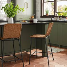 two stools in a kitchen with green cabinets