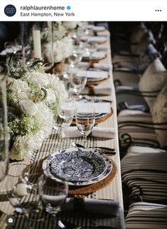 a long table is set with plates and flowers