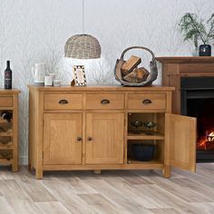 a wooden sideboard with wine bottles on top and a basket next to the fire place