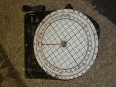 a close up of a compass on the ground with a ruler in front of it