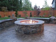 an outdoor fire pit surrounded by stone walls