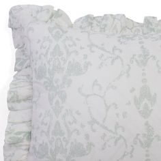 a white and green pillow with ruffled edges