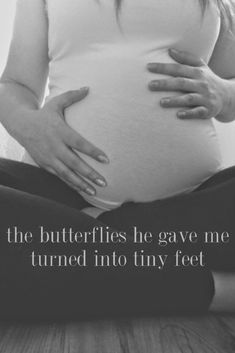 a pregnant woman is sitting on the floor with her belly in her hands, and there is