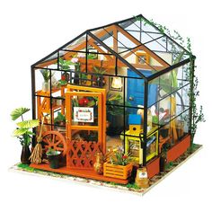 a miniature house made out of plastic with plants and potted plants in the front