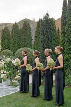 a group of women standing next to each other on top of a lush green field