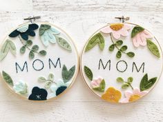 two embroidery hoops with the words mom and flowers on them