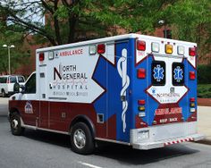 an ambulance is parked on the side of the road in front of some trees and buildings