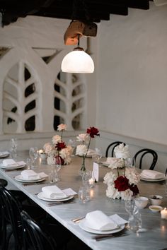 the table is set with white and red flowers