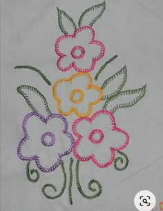 an embroidered piece of cloth with flowers in the center and swirls on each side