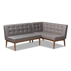 a gray sectional couch with wooden legs and tufted upholstered backrests