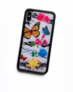 an iphone case with flowers and butterflies on it, sitting on a white surface next to a