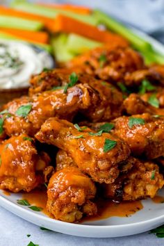 a plate with chicken wings, carrots and celery