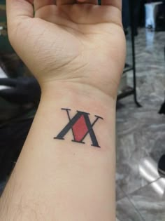 a person's arm with a wrist tattoo that has the letter k on it