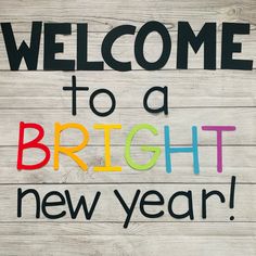 the words welcome to a bright new year written in multicolored letters on wood