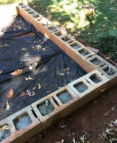 an outdoor area with concrete blocks and tarp on the ground