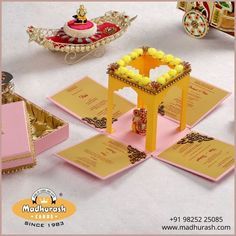 an assortment of decorative items displayed on a white tablecloth with pink and gold accents