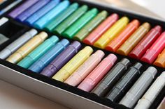 a box filled with lots of different colored crayons on top of a table