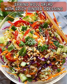 a glass bowl filled with salad and chopsticks on top of a marble table