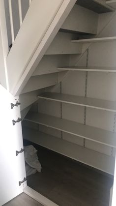 an empty closet under the stairs with no one in it or there is something on the floor