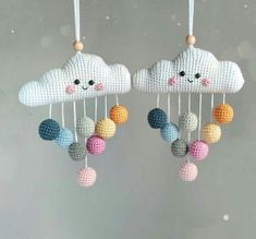 two crocheted mobiles with clouds and balls hanging from them