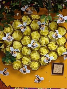 a bunch of cupcakes sitting on top of a table next to some flowers