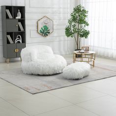 a living room with a large white chair and rug on the floor next to a potted plant