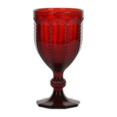 a red glass vase sitting on top of a table