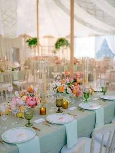 the tables are set with flowers and plates