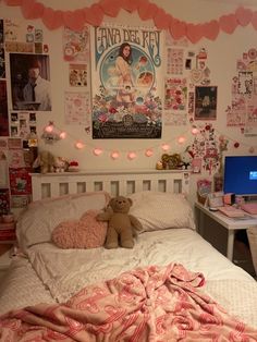 there is a bed with pink sheets and teddy bears on the headboard, next to a computer