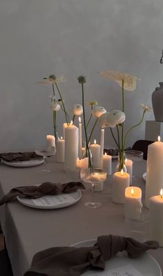 a table topped with lots of white candles