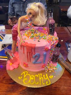 a barbie doll birthday cake with sprinkles and confetti on top