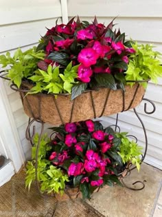 two tiered planters filled with flowers on the side of a house