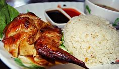 a white plate topped with rice and meat next to sauces on a table top