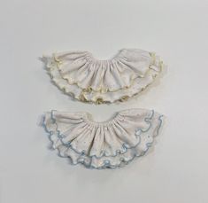 two white scallops with blue ruffles on them against a white background