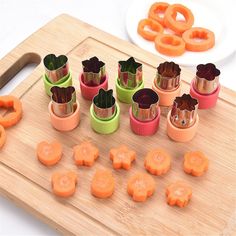 a wooden cutting board topped with lots of cut up carrots and pretzels