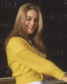 a woman standing in front of a blackboard with writing on it