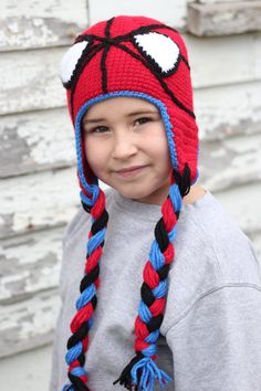 a young boy wearing a red and blue knitted hat