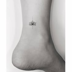 a lotus flower tattoo on the ankle is shown in black and white, as well as dots