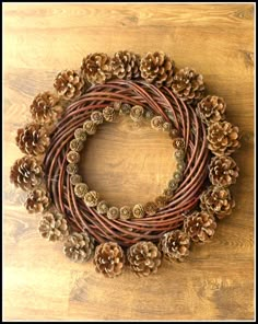 a wreath made out of pine cones on top of a wooden table