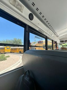 the interior of a school bus with two yellow buses in the background