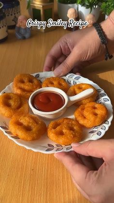 a person is dipping sauce on some fried doughnuts with ketchup in a bowl