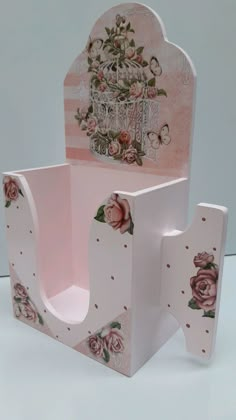 a chair made out of cardboard with flowers on the back and sides, sitting in front of a white background